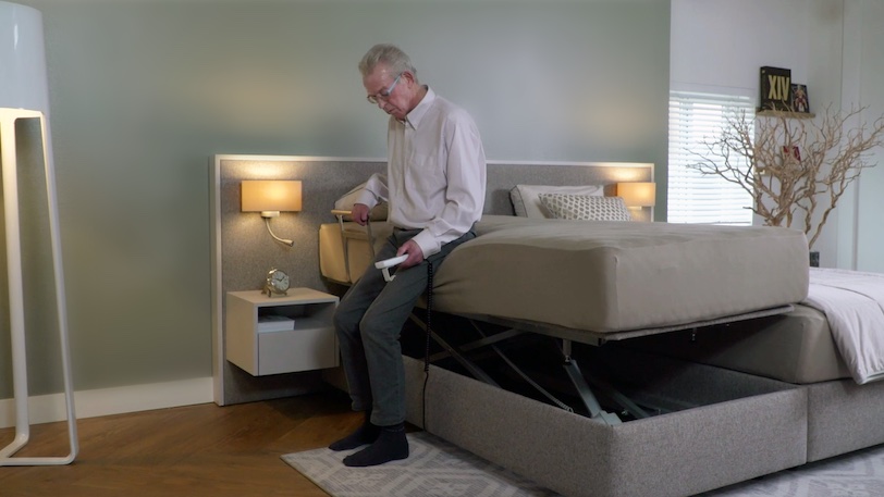 oudere man staat op van hoog laag bed