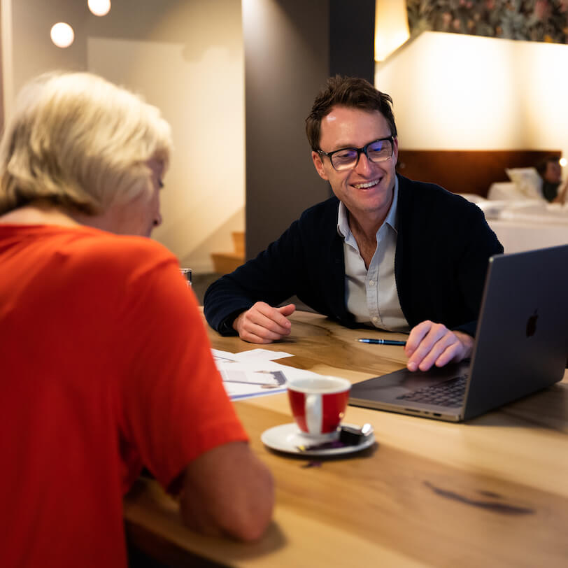 klant zit aan tafel met adviseur Bart voor slaapkamer ontwerp