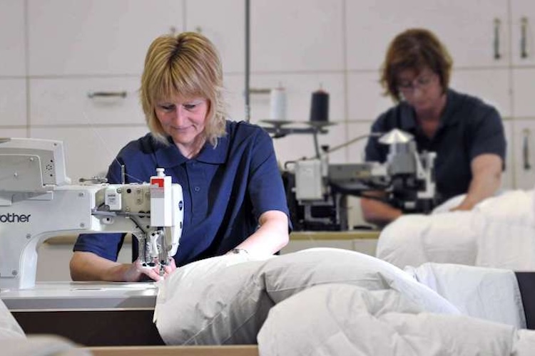 Vrouw stikt donzen dekbed op maat