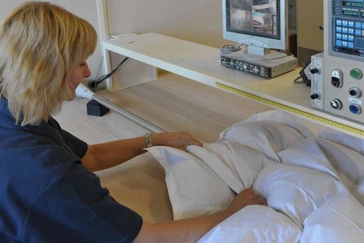 Vrouw vult donzen dekbed in atelier