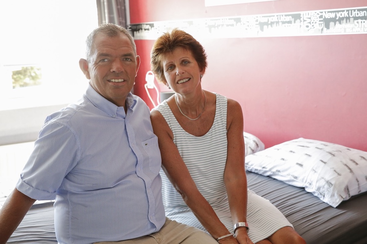 Klant met Parkinson zit op bed samen met partner